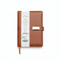 A brown faux-leather planner or notebook cover with a white paper band labeled 'LUXE' and a small gold-tone clasp, shown on a plain white background.