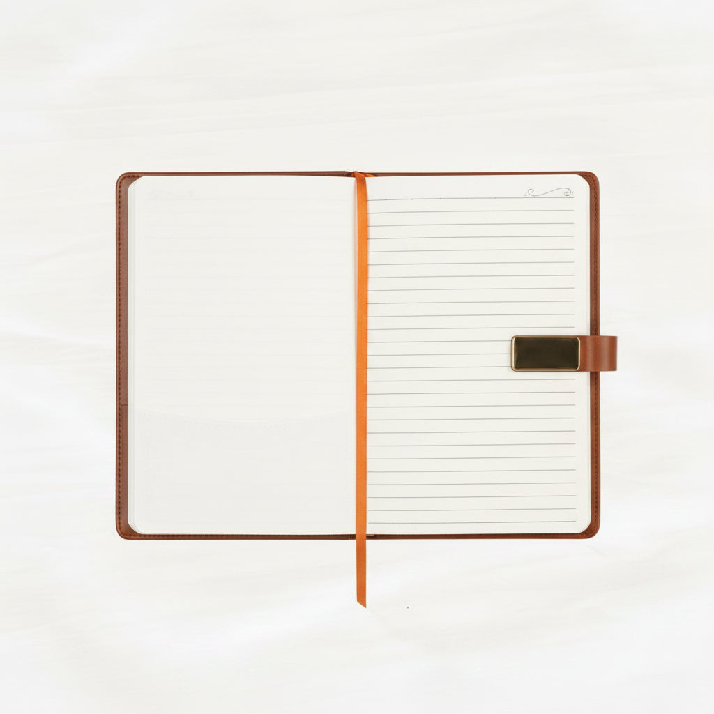 An open notebook with lined pages, a brown leather-like cover, and an orange ribbon bookmark, photographed on a light neutral background.
